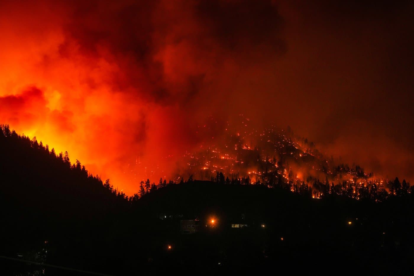 The McDougall Creek wildfire burns on the mountainside above houses in West Kelowna, B.C., on Friday, Aug. 18, 2023. THE CANADIAN PRESS/Darryl Dyck