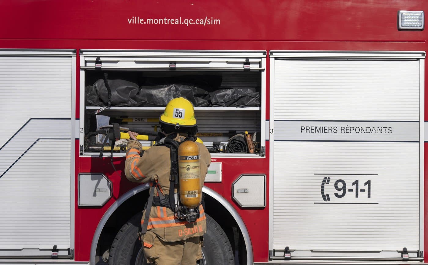 A firefighter puts gear away after responding to an alarm in Pointe Claire, a borough of Montreal, Thursday March 7, 2024. THE CANADIAN PRESS/Christinne Muschi