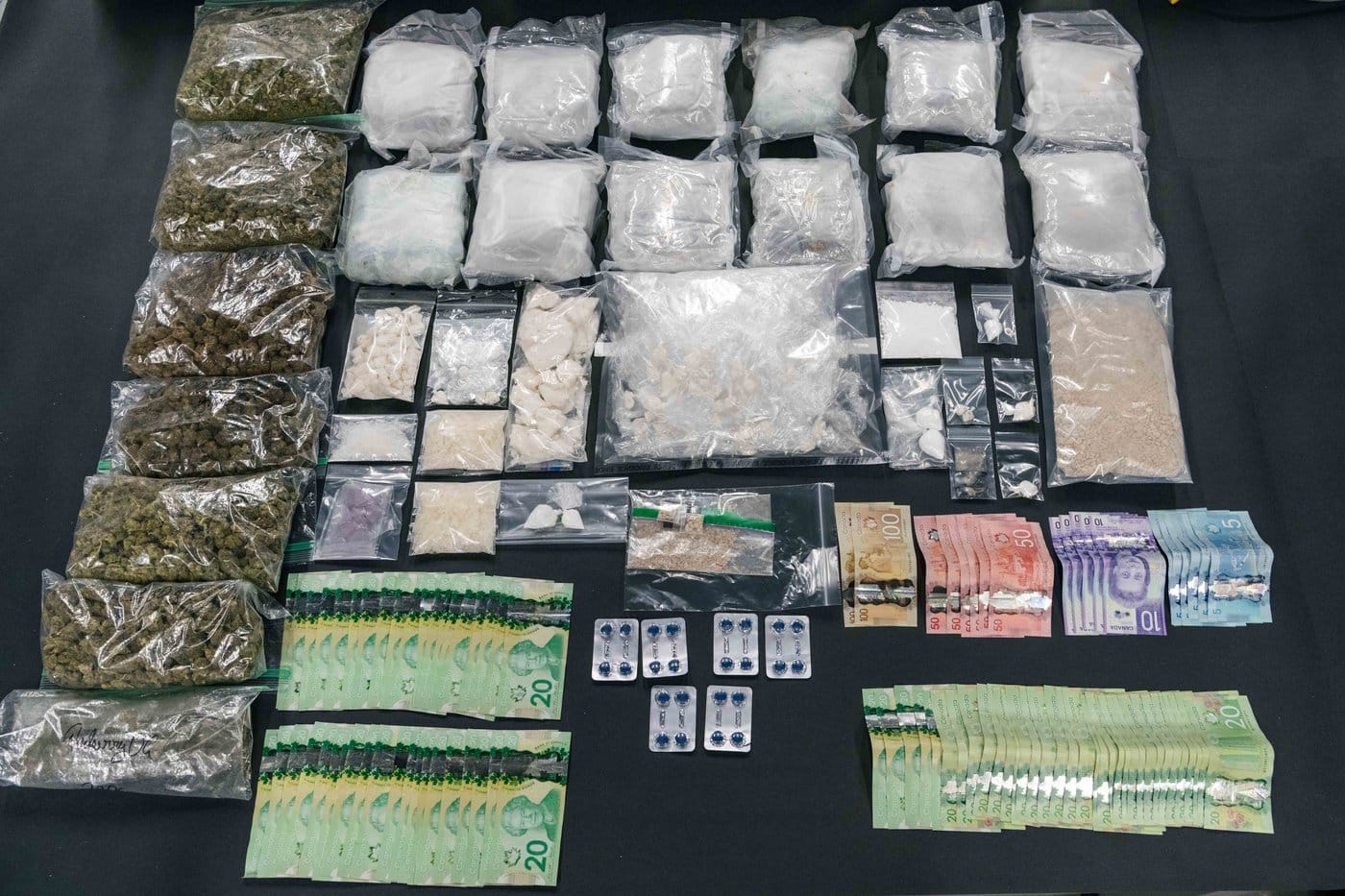 Items seized in a multi-month drug trafficking investigation in Surrey, B.C., are displayed by investigators, in this handout photo. THE CANADIAN PRESS/Handout - Surrey Police Service (Mandatory Credit)