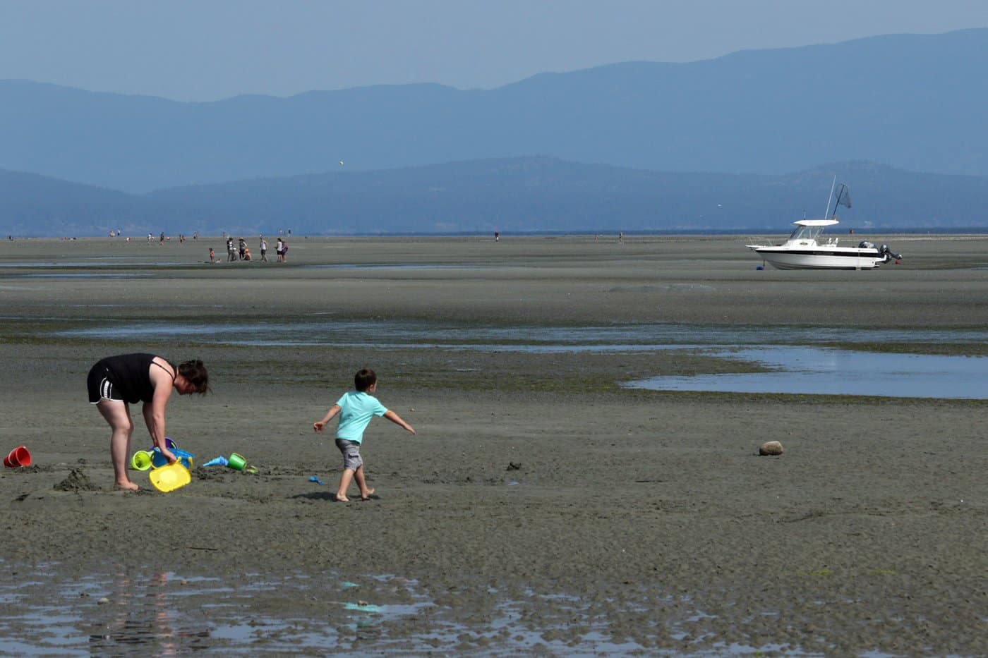 People enjoy the heat wave across Vancouver Island during a low tide at Rathtrevor Beach Provincial Park in Parksville, B.C., on Friday, July 27, 2018. THE CANADIAN PRESS/Chad Hipolito