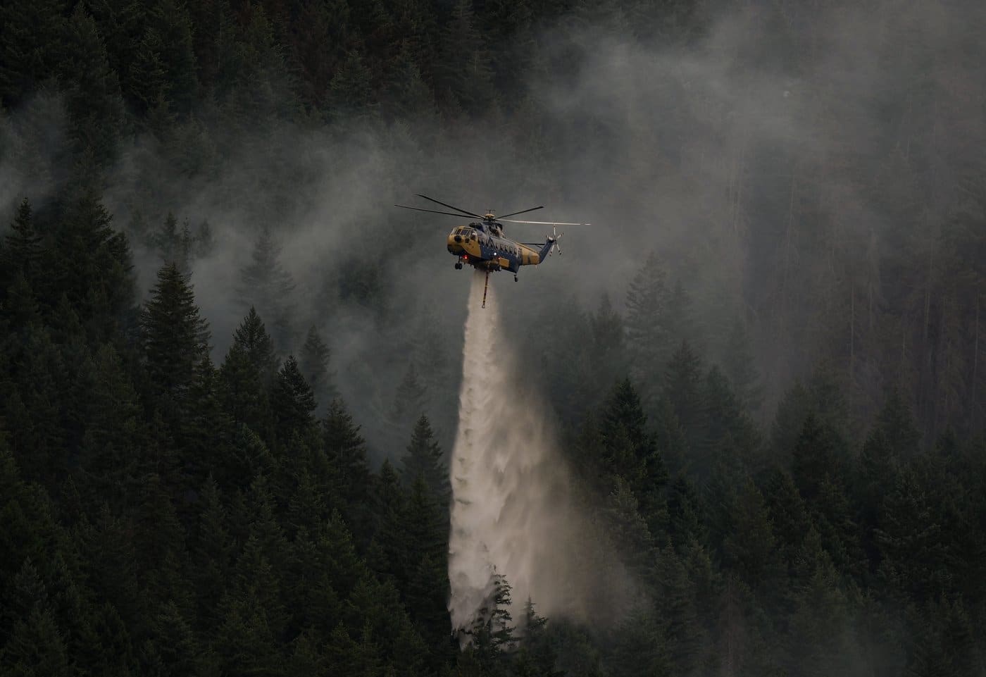 A helicopter drops water while fighting the Brunswick Creek wildfire in Boston Bar, B.C., on Thursday, July 9, 2026. THE CANADIAN PRESS/Darryl Dyck