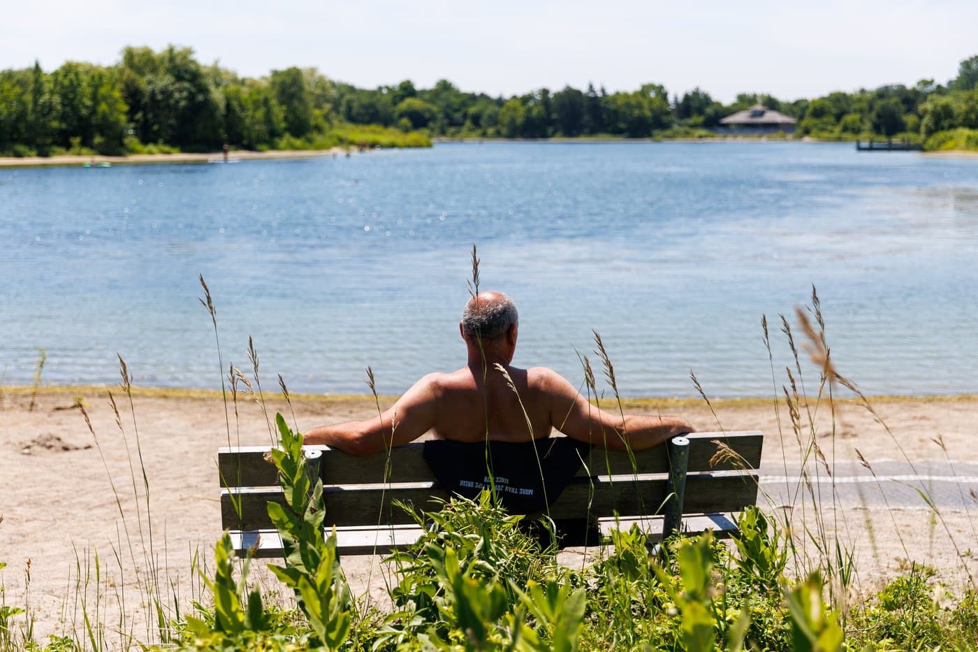 A man basks in the sun at the Lakefront Promenade Beach in Mississauga, Ont., on Tuesday, July 14, 2026. THE CANADIAN PRESS/Keito Newman