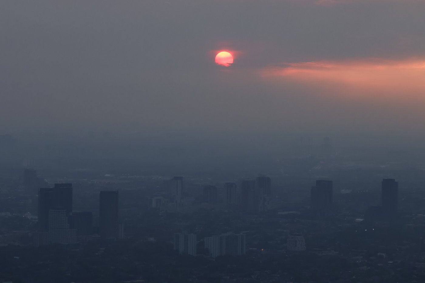 Buildings are seen from the observation deck of the CN Tower as smoke from forest fires in Northwestern Ontario blankets the city of Toronto, Thursday, July 16, 2026. THE CANADIAN PRESS/Cole Burston