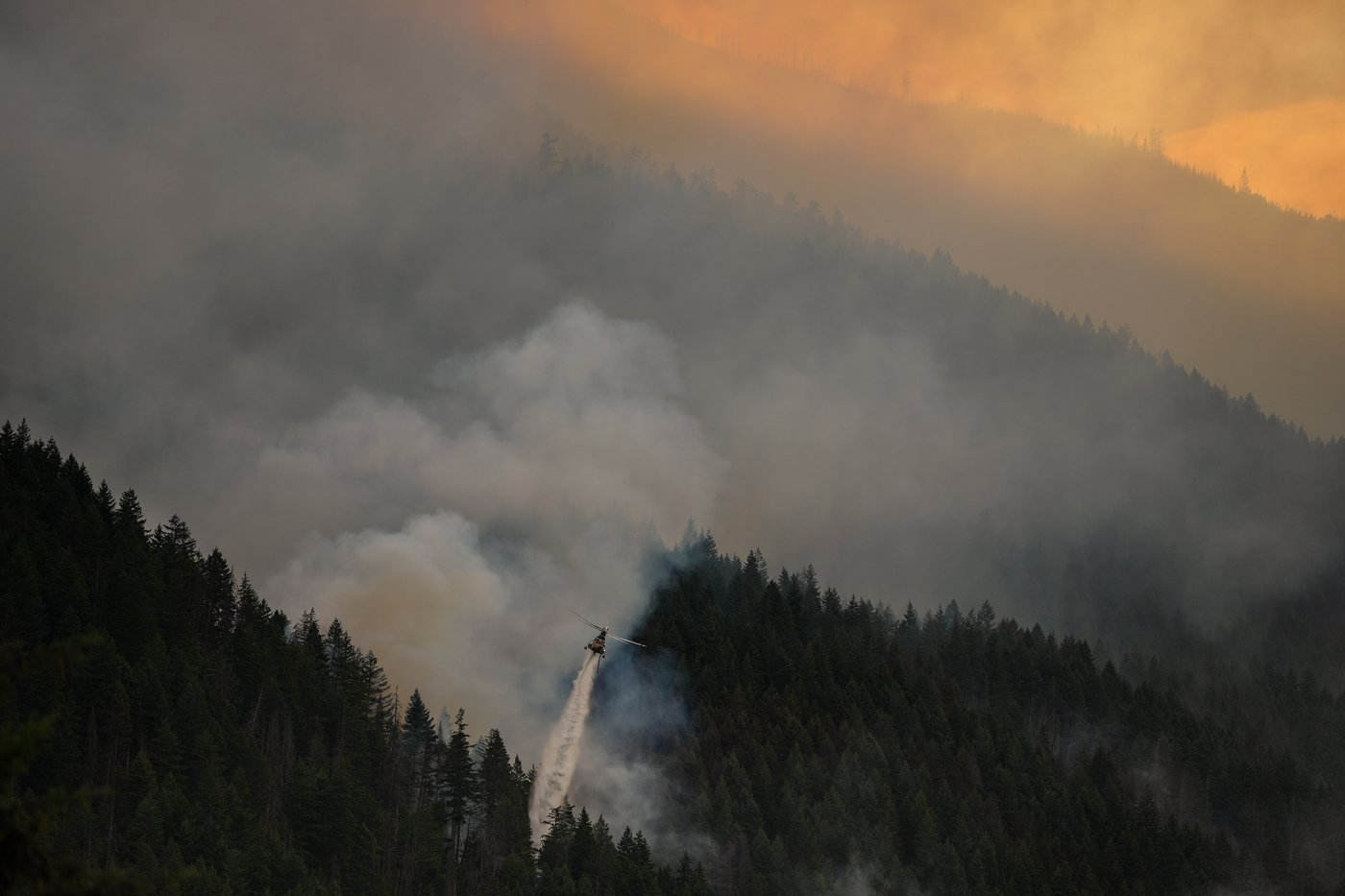 A helicopter drops water while fighting the Brunswick Creek wildfire in Boston Bar, B.C., on Thursday, July 9, 2026. THE CANADIAN PRESS/Darryl Dyck