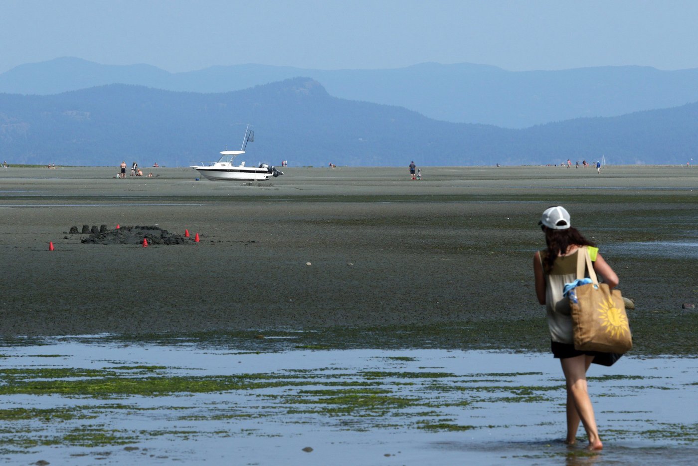 People enjoy the heat wave across Vancouver Island during a low tide at Rathtrevor Beach Provincial Park in Parksville, B.C., on Friday, July 27, 2018. THE CANADIAN PRESS/Chad Hipolito