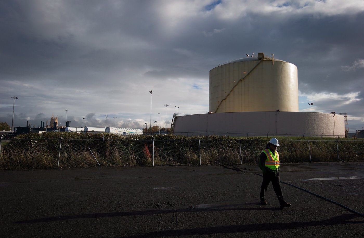 A FortisBC employee walks past a storage tank at the existing FortisBC Tilbury LNG facility before the groundbreaking for an expansion project in Delta, B.C., on Tuesday October 21, 2014. The existing LNG facility on the site opened in 1971. THE CANADIAN PRESS/Darryl Dyck